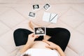 A cute pregnant belly and x ray ultrasound scan of baby. asian young pregnant female relax in the room looking at her child Royalty Free Stock Photo