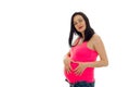 Cute pregnant girl with dark hair touching her big belly and looking at the camera isolated on white background Royalty Free Stock Photo