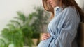 A cute pregnant woman sits in bed. The concept of a happy pregnancy. 9 months of waiting for a baby.