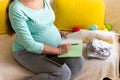 Cute Pregnant Woman writing packing list for maternity hospital With Notebook Prepares bags. Young Ledy In Pregnancy Royalty Free Stock Photo