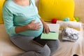 Cute Pregnant Woman writing packing list for maternity hospital With Notebook Prepares bags. Young Ledy In Pregnancy Royalty Free Stock Photo