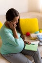 Cute Pregnant Woman writing packing list for maternity hospital With Notebook Prepares bags. Young Ledy In Pregnancy Royalty Free Stock Photo