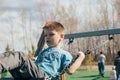 Cute preschool boy swinging on a swing at the playground. Summer activity for children, lifestyle Royalty Free Stock Photo