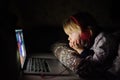 Cute preschool boy wearing headphones is watching cartoon movie by laptop before sleeping in bed or early in the morning right Royalty Free Stock Photo