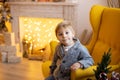 Cute preschool child, blond boy with pet dog, playing in decorated Christmas room Royalty Free Stock Photo