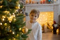 Cute preschool child, blond boy with pet dog, playing in decorated Christmas room Royalty Free Stock Photo