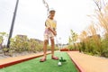 Cute preschool girl playing mini golf with family. Happy child having fun with outdoor activity. Summer sport for Royalty Free Stock Photo