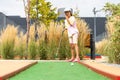 Cute preschool girl playing mini golf with family. Happy child having fun with outdoor activity. Summer sport for Royalty Free Stock Photo