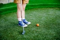 Cute preschool girl playing mini golf with family. Happy toddler child having fun with outdoor activity. Summer sport Royalty Free Stock Photo