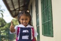 A cute preschooler asian girl makes a thumbs up sign while walking outside her classroom. At a provincial primary school in Bohol Royalty Free Stock Photo