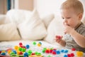 Cute preschooler child boy plays with mosaic at home. A blond little toddler playing in kid`s room. Leisure activities Royalty Free Stock Photo