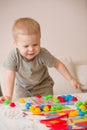 Cute preschooler child boy plays with mosaic at home. A blond little toddler playing in kid`s room. Leisure activities Royalty Free Stock Photo