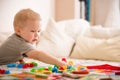 Cute preschooler child boy plays with mosaic at home. A blond little toddler playing in kid`s room. Leisure activities. indoors. Royalty Free Stock Photo