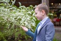 Cute preshcool boy, enjoying white flowers bush in blooming garden, springtime Royalty Free Stock Photo