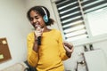 Preteen black girl holding microphon singing karaoke at home, recording songs for contest. Children's lifestyle concept