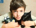 Cute preteen boy with black cat on the table