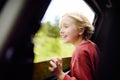 Cute preteen boy looking out through window of car during family road trip Royalty Free Stock Photo