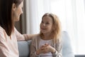 Cute preteen daughter sit on sofa talk to caring mother Royalty Free Stock Photo