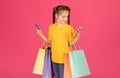 Cute Preteen Girl Holding Credit Card And Shopping Bags And Using Smartphone Royalty Free Stock Photo