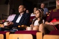 Preteen girl with parents watching movie in cinema