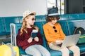 Preteen kids sitting in waiting hall with laptop and passport Royalty Free Stock Photo