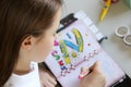 Cute preteen little girl writing her dreams in diary.