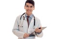 Cute pretty brunette male doctor in uniform with stethoscope on his neck posing and smiling on camera isolated on white Royalty Free Stock Photo