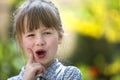 Cute pretty child girl with funny expression outdoors on blurred sunny green and yellow bright background Royalty Free Stock Photo