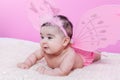 Cute, pretty, happy, chubby and smiling baby girl, with pink butterfly wings Royalty Free Stock Photo