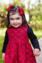 Cute, pretty, happy, smiling toddler baby girl, with a naughty playful smile with elegant red and black dress. Royalty Free Stock Photo