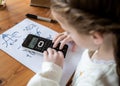 Cute pretty young girl doing complex maths writing calculations genius child at home school scientific calculator advanced Royalty Free Stock Photo