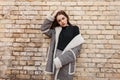 Cute pretty young woman in elegant checkered coat with white fur in a black stylish t-shirt in vintage gray pants Royalty Free Stock Photo