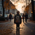 Cute primary school students back view on an evening street