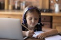 Cute primary schoolkid doing school task at home