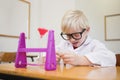 Cute pupil dressed up as scientist in classroom