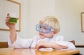 Cute pupil dressed up as scientist in classroom