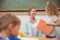 Cute pupil looking her teacher during class presentation