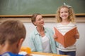 Cute pupil smiling at camera during class presentation