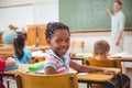 Cute pupil smiling at camera in classroom Royalty Free Stock Photo