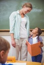 Cute pupil smiling to her teacher during class presentation