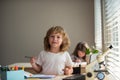 Cute pupil writing at desk in classroom at the elementary school. Student boy doing test in primary school. Children Royalty Free Stock Photo