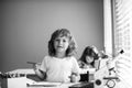 Cute pupil writing at desk in classroom at the elementary school. Student boy doing test in primary school. Children