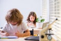 Cute pupil writing at desk in classroom at the elementary school. Student girl doing test in primary school. Children