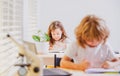 Cute pupil writing at desk in classroom at the elementary school. Student girl doing test in primary school. Children Royalty Free Stock Photo