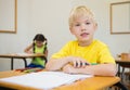 Cute pupils colouring at desks in classroom