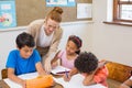 Cute pupils getting help from teacher in classroom Royalty Free Stock Photo