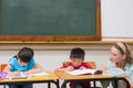 Cute pupils getting help from teacher in classroom