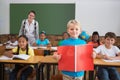 Cute pupils smiling at camera in classroom