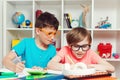 Cute pupils writing at desk in classroom. Education, elementary school. Student doing test in primary school