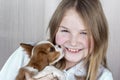 Cute purebred puppy licks face of happy young girl. Royal Cavalier King Charles Spaniel Dog